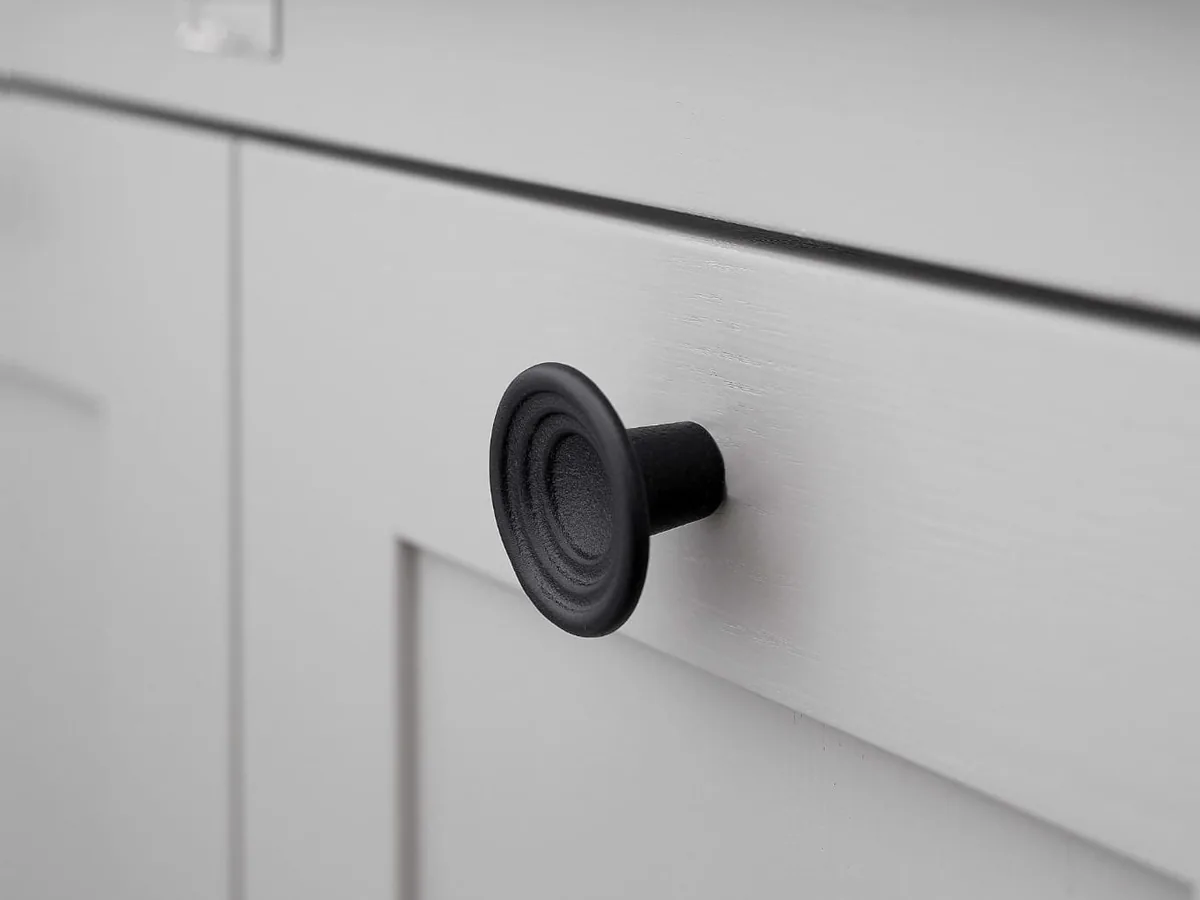 Knopp i gjutjärn på en köksskåpslucka